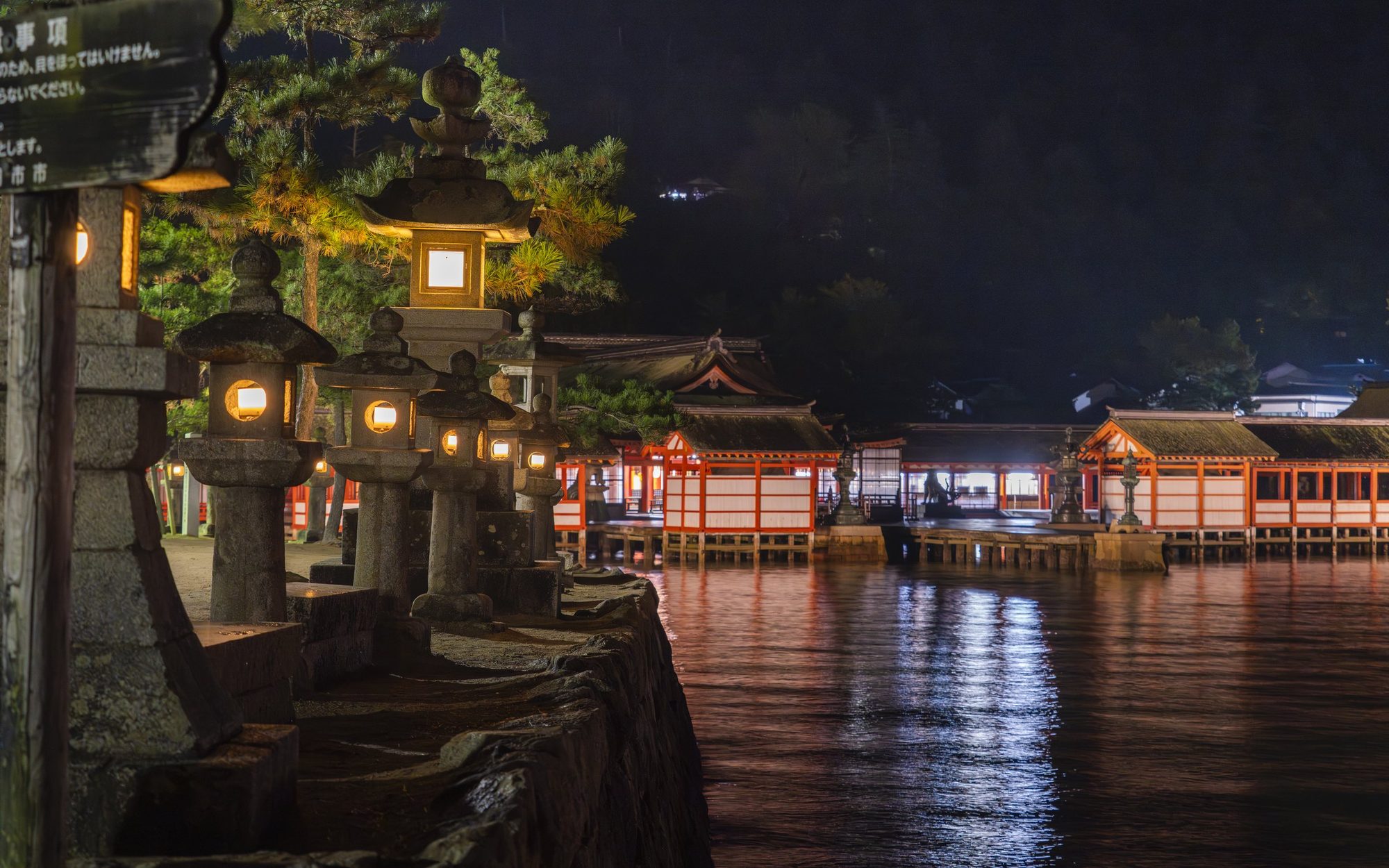 夜、灯りに浮かぶ嚴島神社の大鳥居と水鏡
