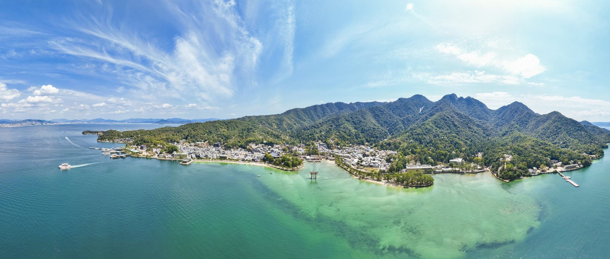 夜の宮島を海上から望む。社殿と町の灯り