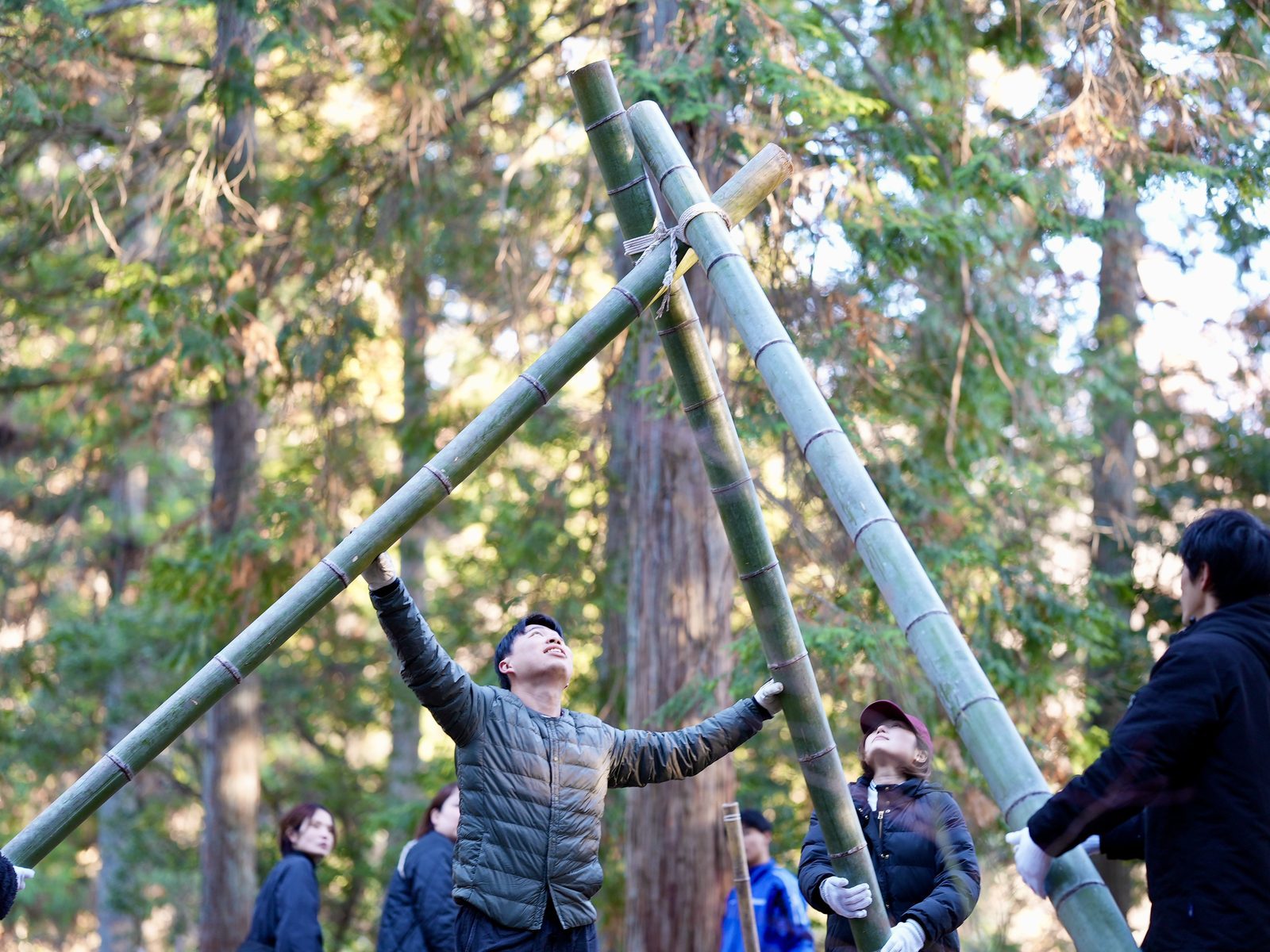 森で竹を組み上げる人々